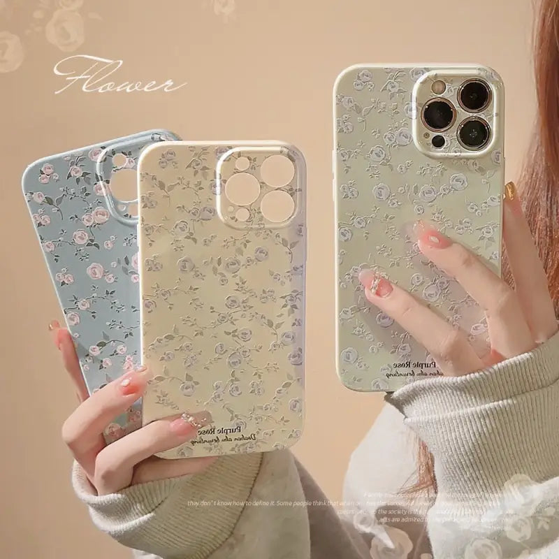 a woman holding a phone case with flowers on it