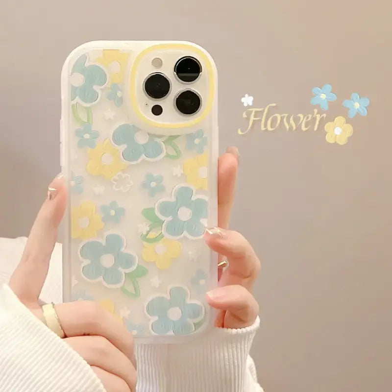 A woman holding a phone case with flowers on it