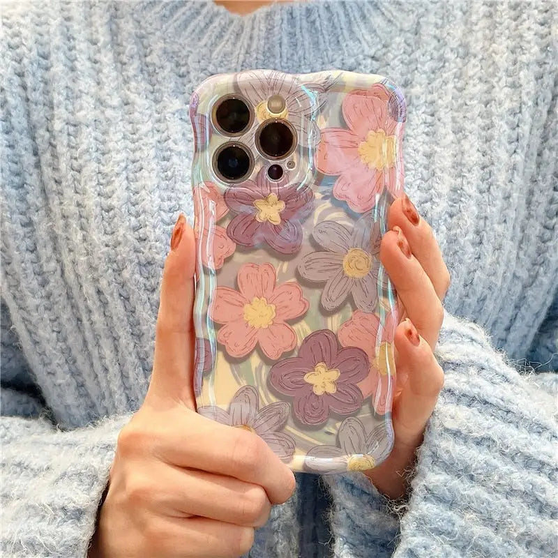 a woman holding a phone case with flowers on it