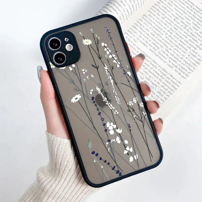 A woman holding a phone case with flowers on it