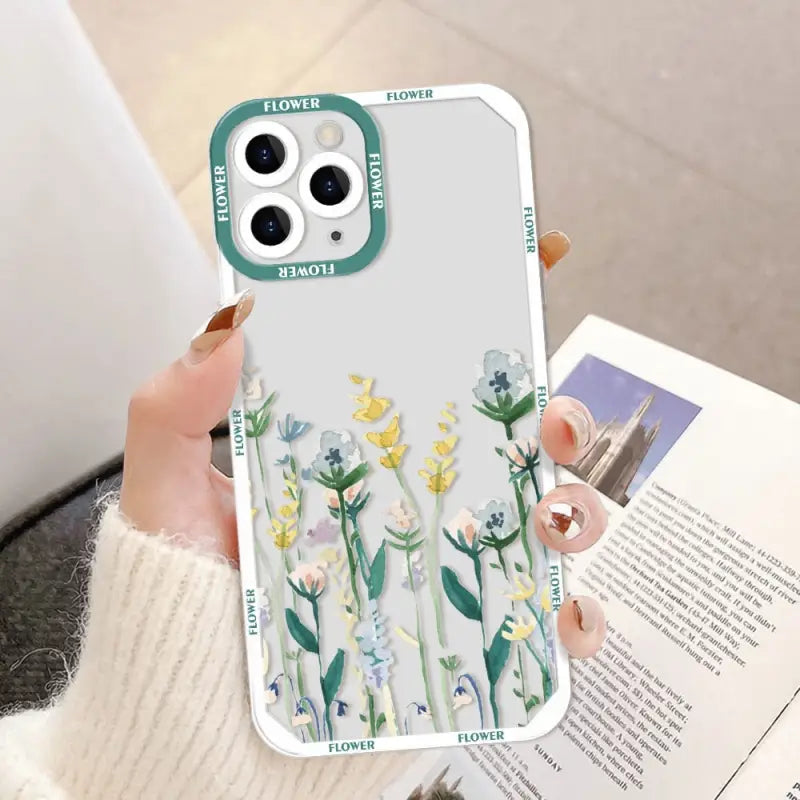 a woman holding a phone case with flowers on it
