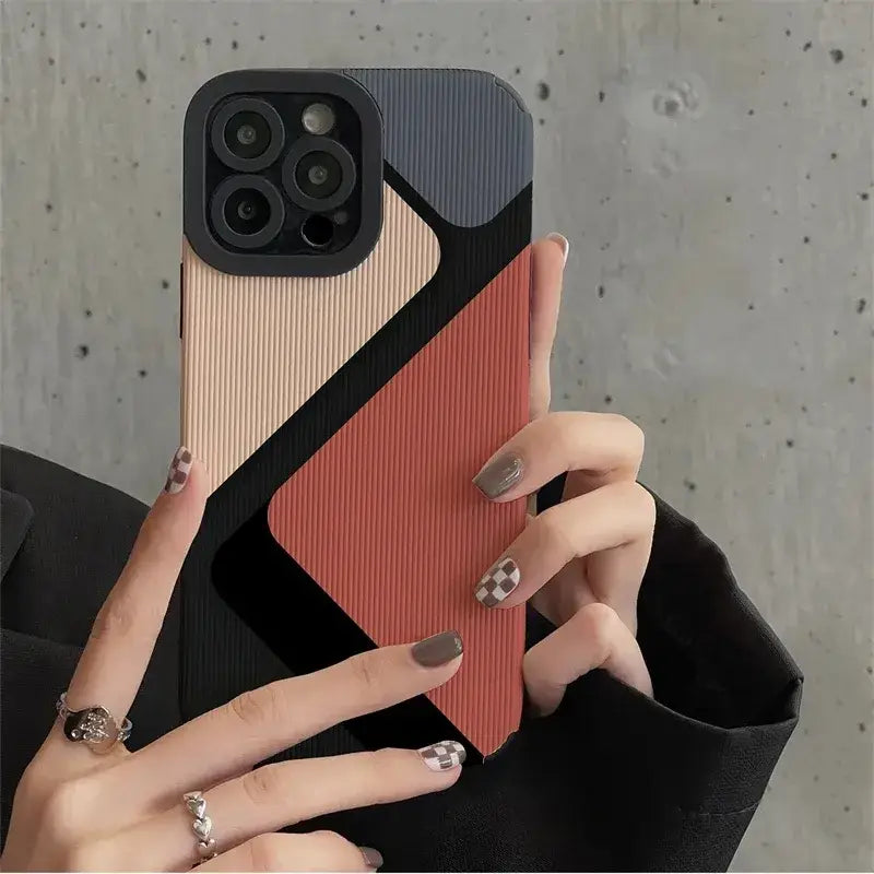A woman holding a phone case with a geometric design