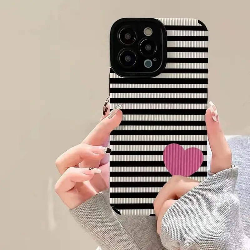 a woman holding a phone case with a heart on it