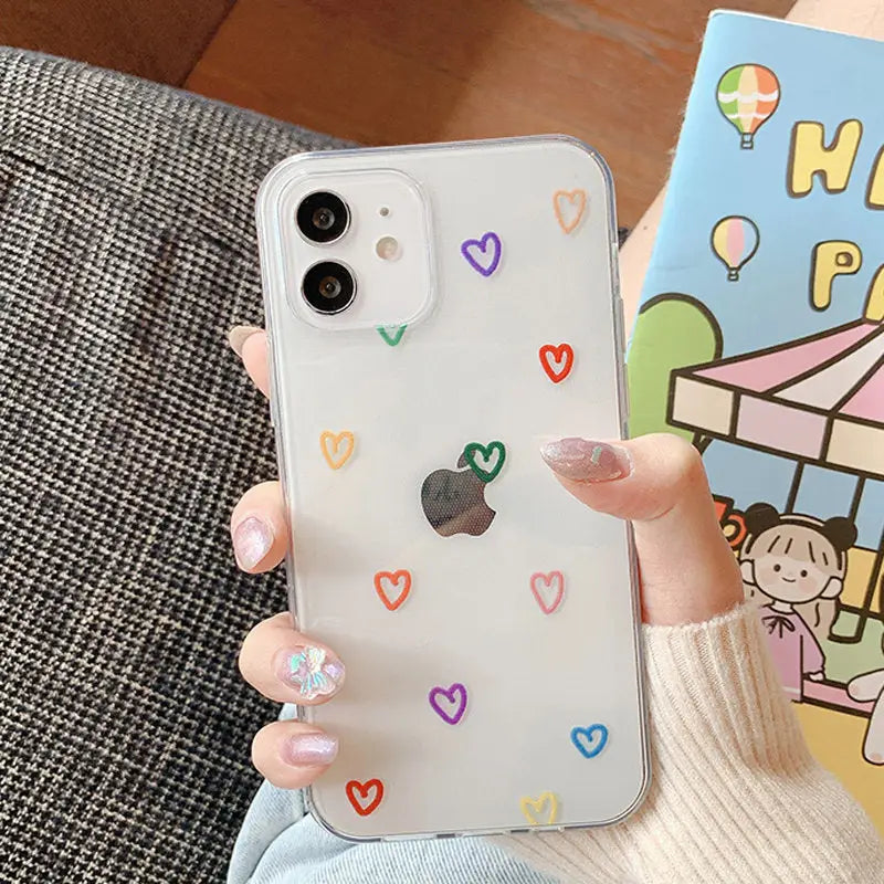A woman holding a phone case with hearts on it
