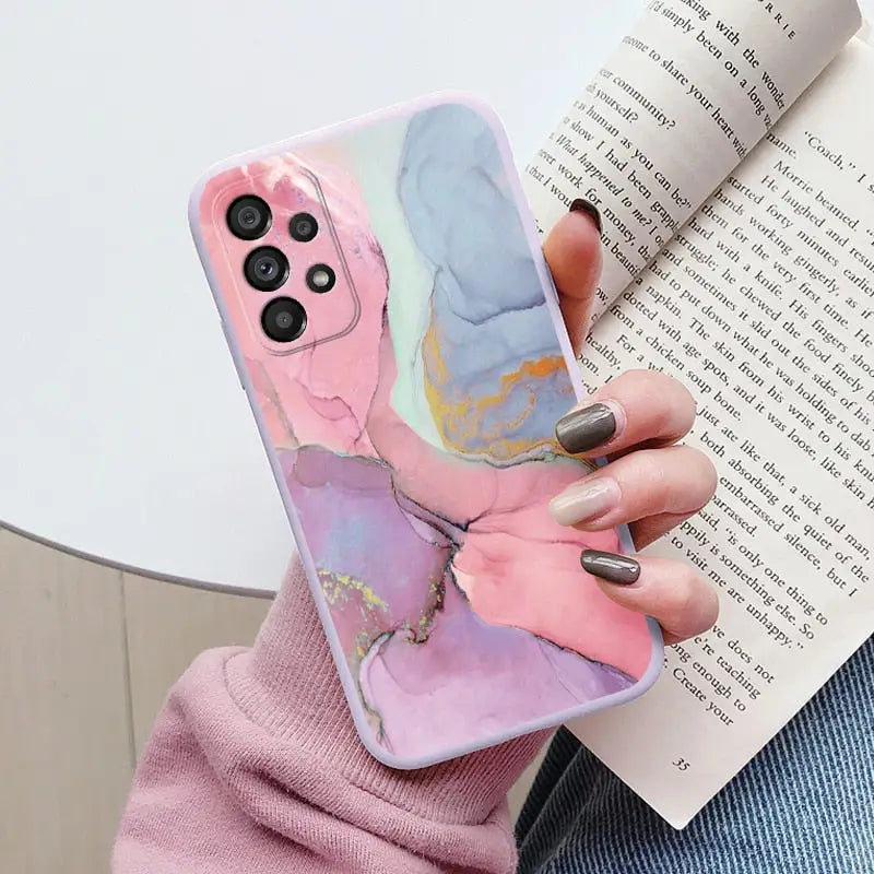 a woman holding a phone case with a marble pattern
