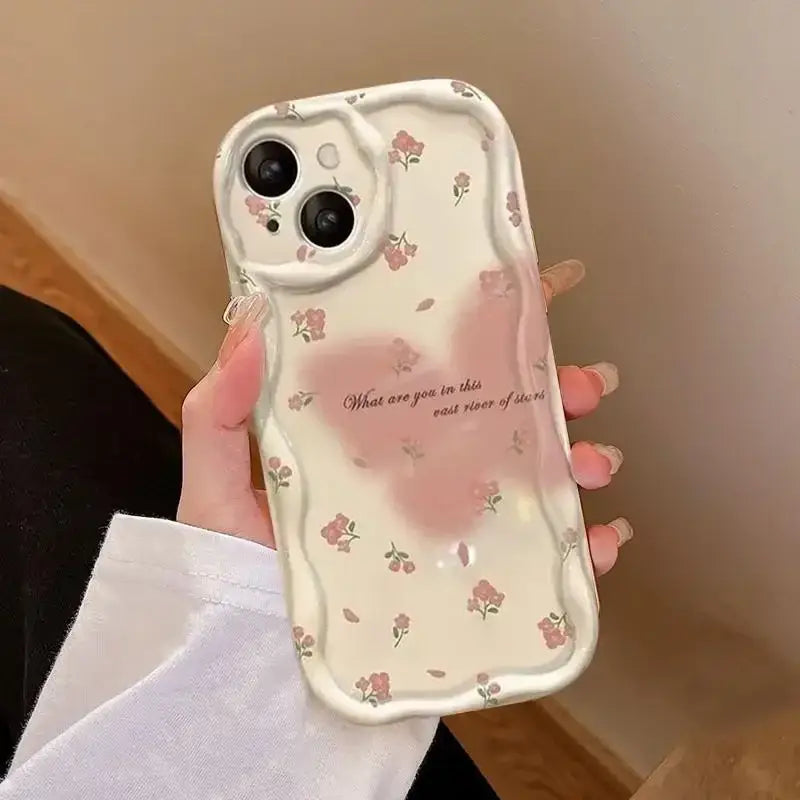 A woman holding a phone case with a pink flower design