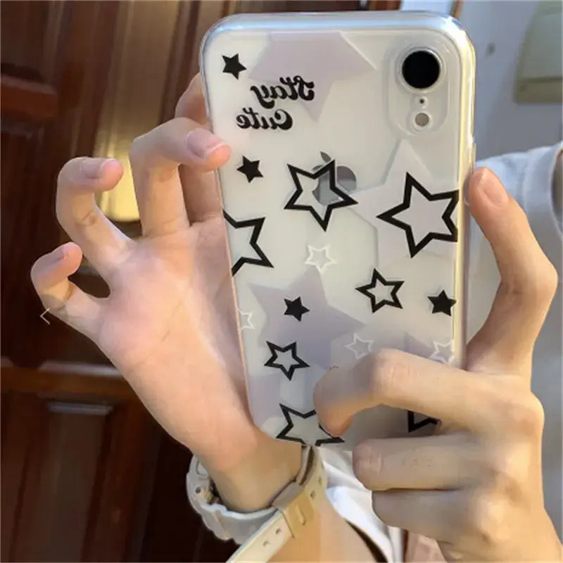 A woman holding up a phone case with stars on it