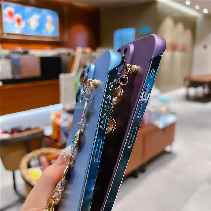 a woman holding a phone with a chain attached to it