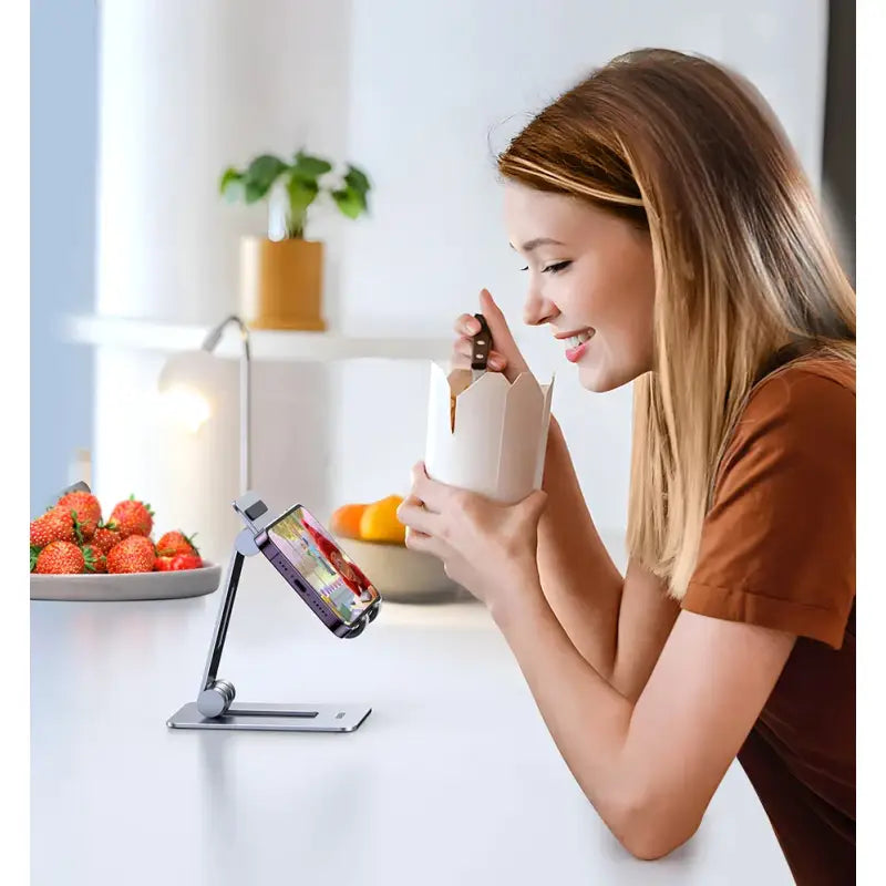 A woman using her phone to drink from a cup
