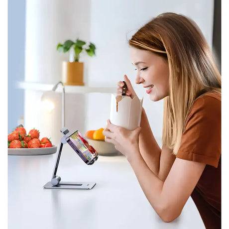 A woman using her phone to drink from a cup