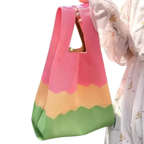 a woman holding a pink and green bag