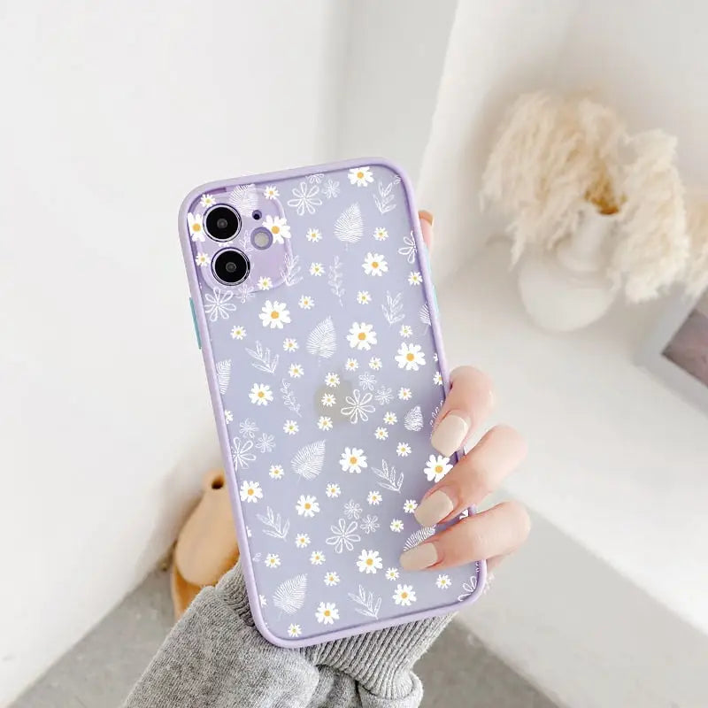 A woman holding a purple phone case with white flowers on it