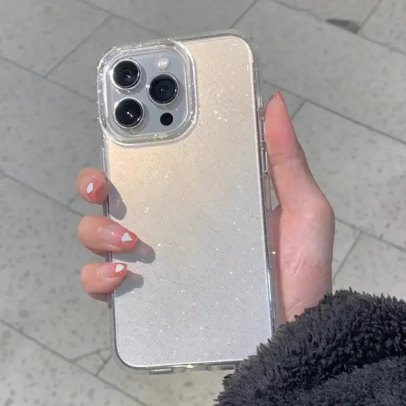 a woman holding a silver glitter iphone case