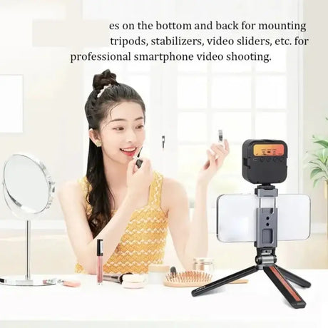 woman sitting at a table with a camera and a mirror