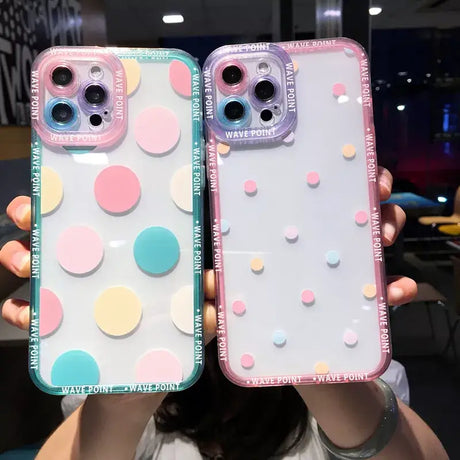 A woman holding two iphone cases with colorful circles on them