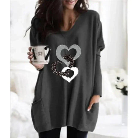 a woman wearing a grey sweater with a heart on it