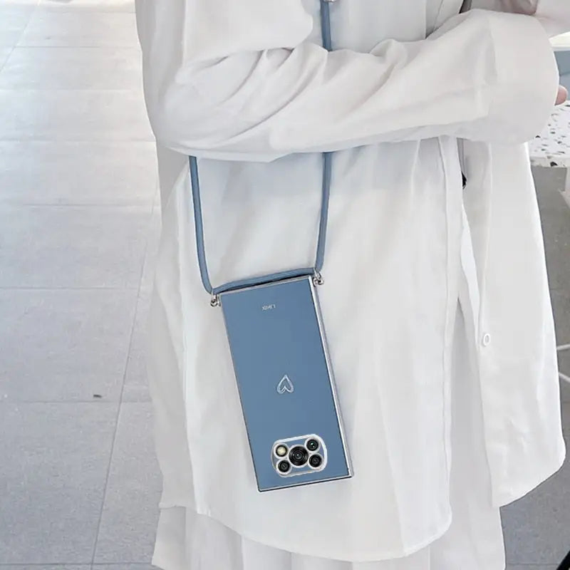 a woman in a white coat holding a blue cell phone