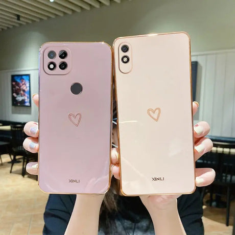 two women holding up their iphones with hearts on them