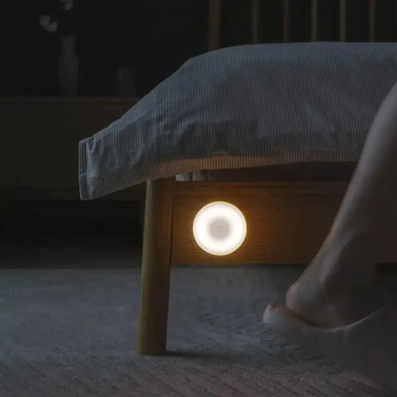 a person sitting on a bed with a light on their foot