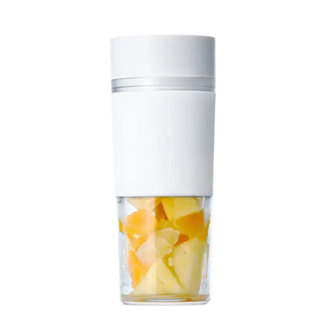 a glass filled with sliced fruit and a white lid