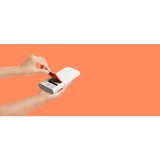 a hand holding a credit card in front of an orange background