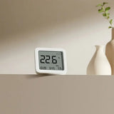 a white clock sitting on top of a table