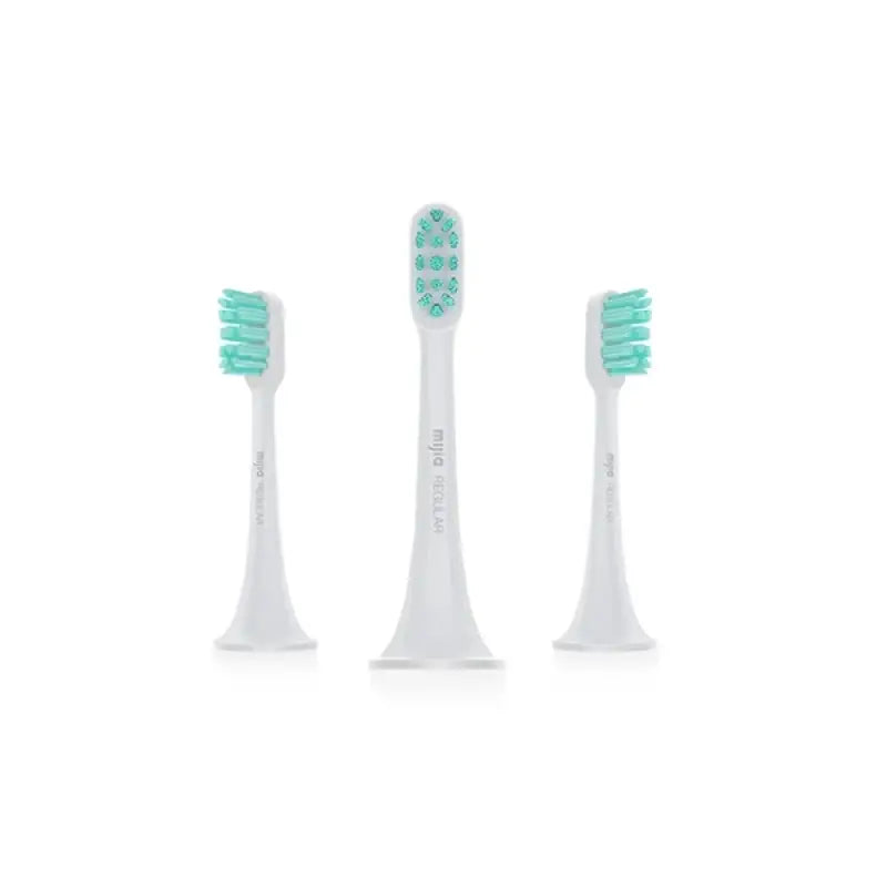 three toothbrushes with green bristles on a white background