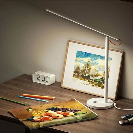 a lamp on a desk next to a picture