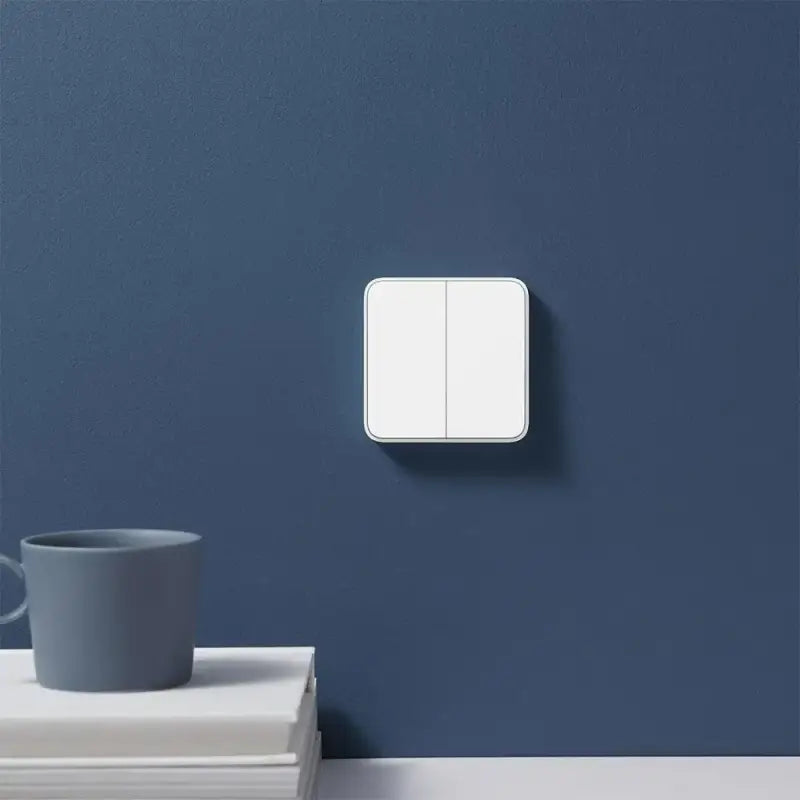 a light switch on a wall next to a cup