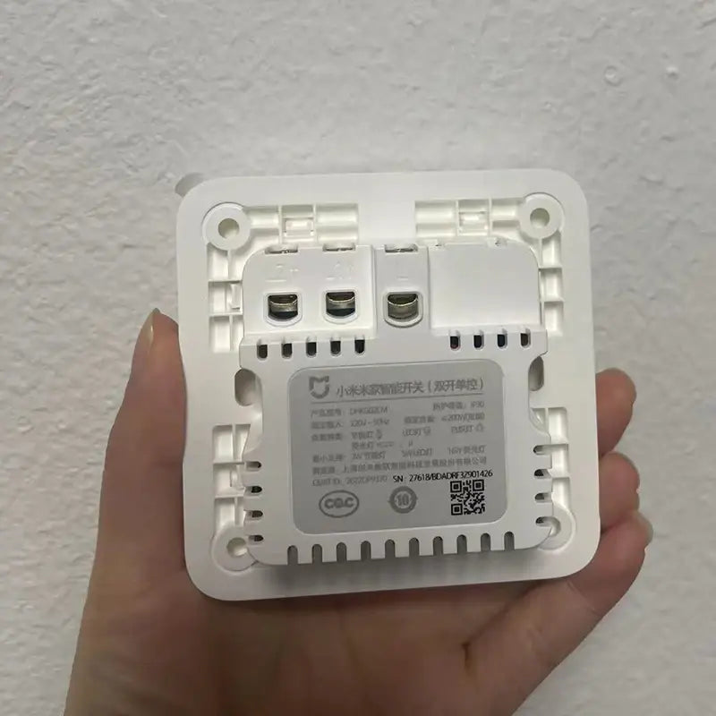a hand holding a white power switch