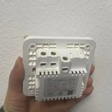 a hand holding a white electrical device