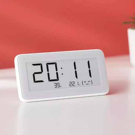 a white clock sitting on top of a table