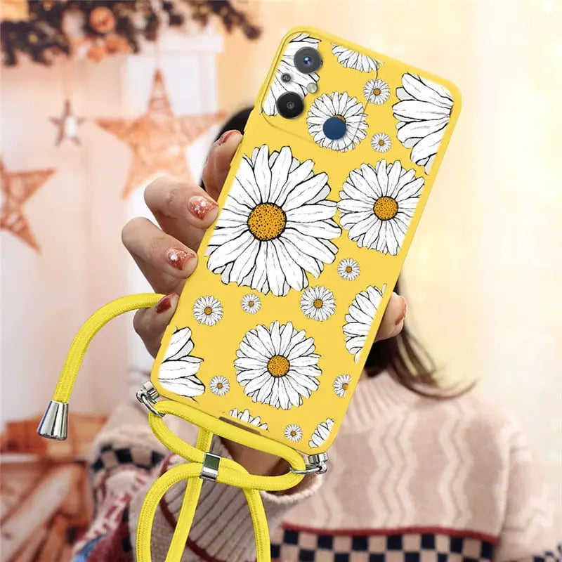there is a woman holding a phone with a yellow case with white flowers