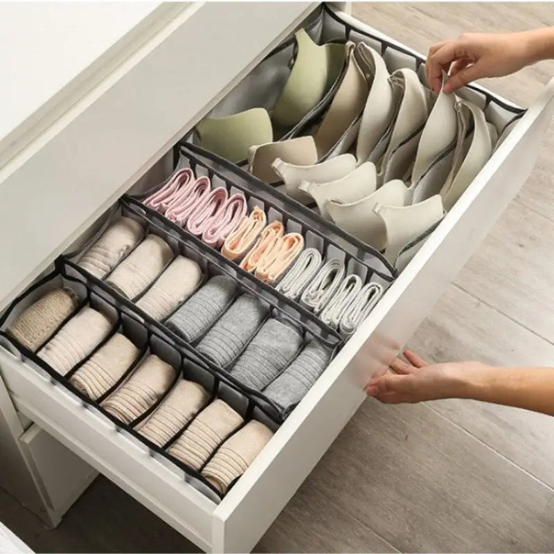 a woman is putting a pair of shoes in a drawer