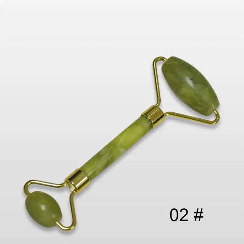 a close up of a green jade roller with a metal handle