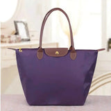 a purple purse with brown handles and a brown handle