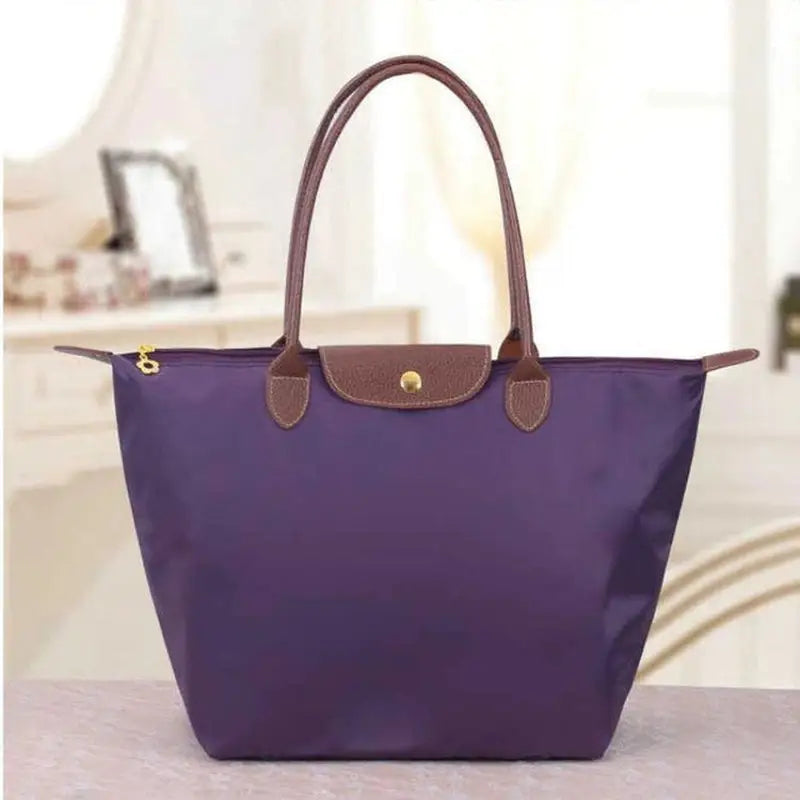 a purple purse with brown handles and a brown handle