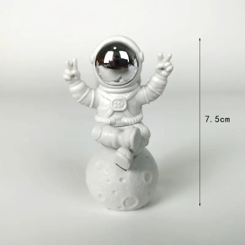 a small toy astronaut sitting on top of a snowman