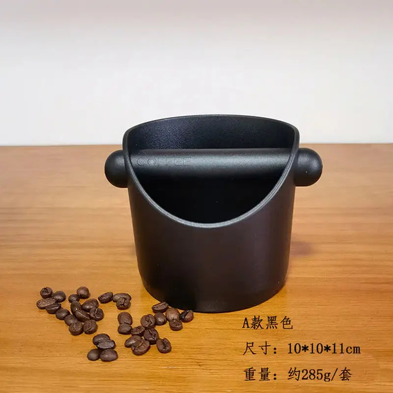 a black cup with coffee beans on a wooden table