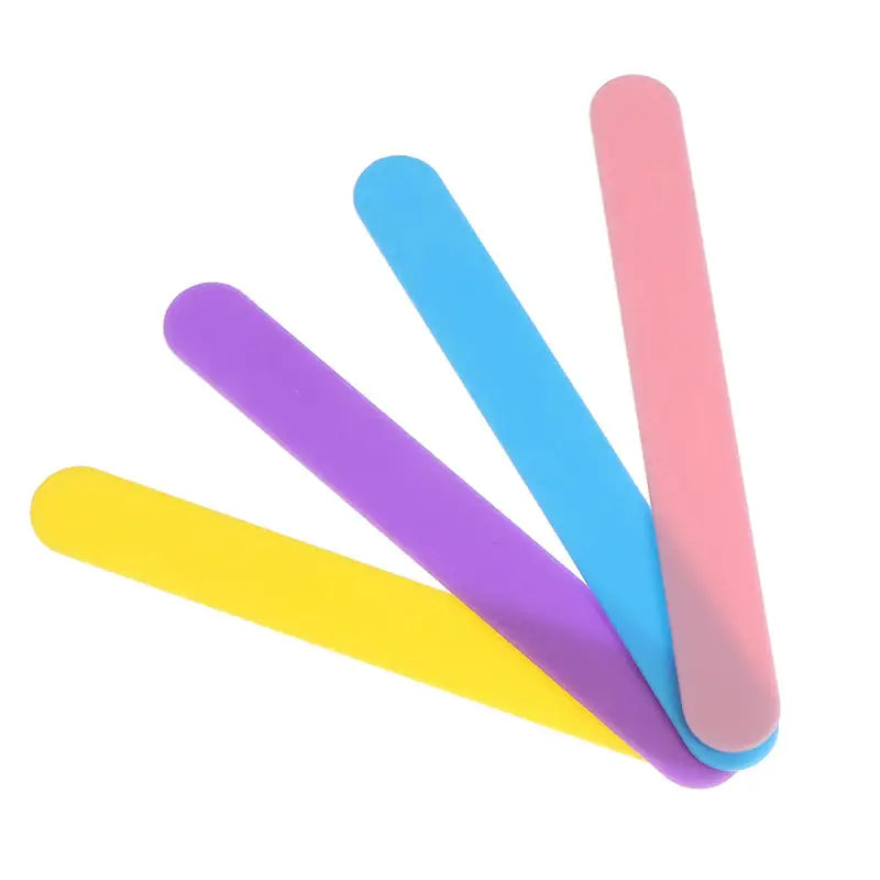 three different colored plastic spoons on a white background