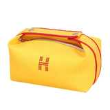 a yellow bag with a red handle