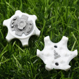 two white plastic gears sitting on top of green grass