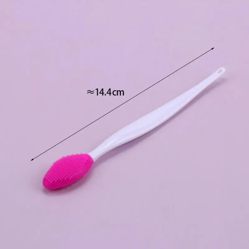 a close up of a toothbrush with a pink bristles on a pink background