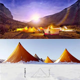 a group of tents in the snow with a mountain in the background