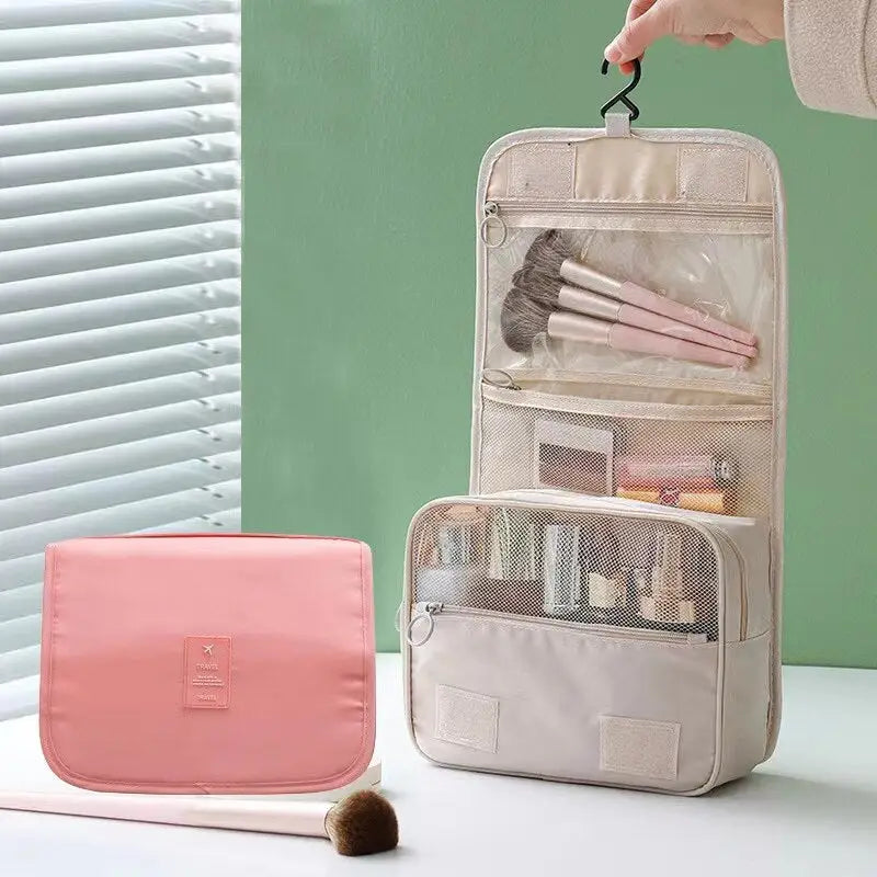 a person holding a pink bag with makeup brushes and a brush
