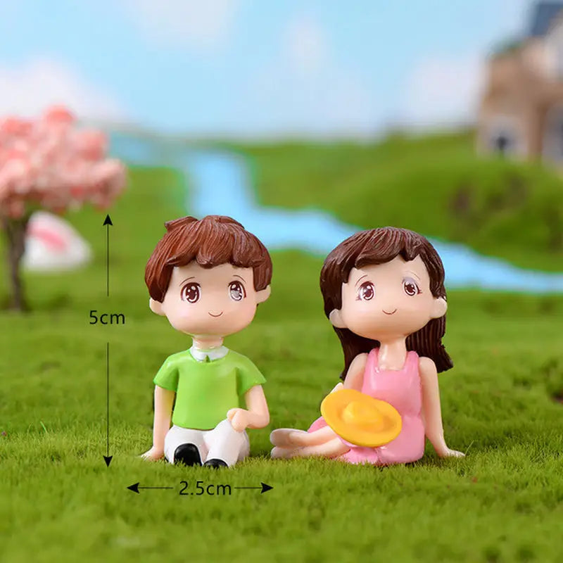 a couple sitting on the grass with a small toy