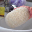 a hand holding a piece of bread in front of a sink