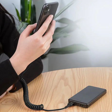 a woman is holding a phone and charging it