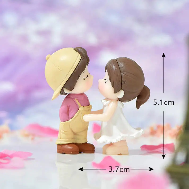 there are two figurines of a boy and a girl holding hands