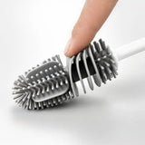 a hand holding a brush with a white handle